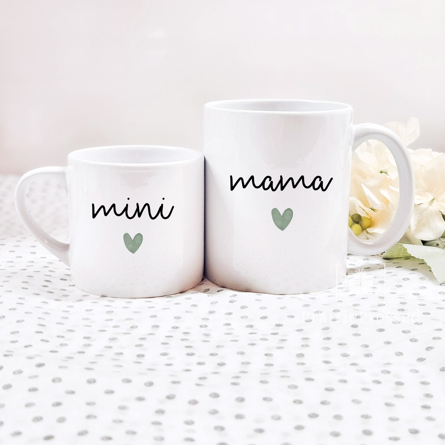 Adorable Mama Mini Ceramic Mother's Day Mug set with cute font and green heart on each. Mug set includes one child size 5oz white mug and one 11oz white standard coffee mug