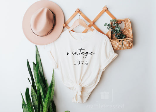 Natural Cream Color Soft Tshirt with the Phrase Vintage 1974 in beautiful font. The Date can be customized for birthday
