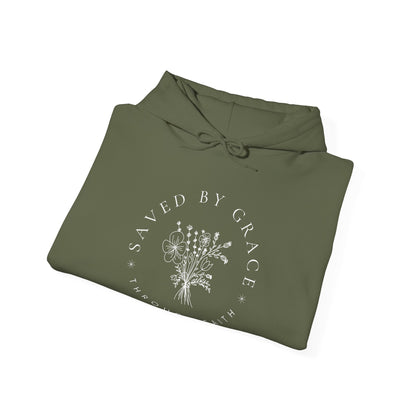 Folded olive green hoodie with 'Saved by Grace' text and floral design on a white background