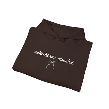 Folded brown sweatshirt with 'make heaven crowded' text on a white background