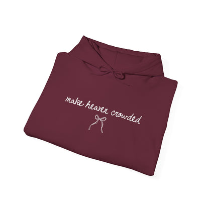 Folded maroon hoodie with 'make heaven crowded' text on a white background