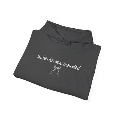 Folded dark gray hoodie with 'make heaven crowded' text on a white background