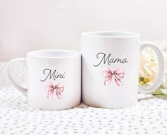 Mama and Mini Ceramic Coffee Mug set in sizes 5oz and 11oz. Script font Mama with Coquestte pink Bow and Mini with matching bow